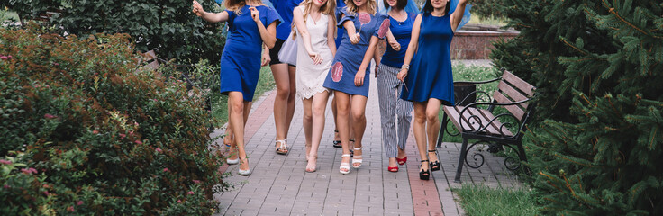 Girls in blue walk along the track at a bachelorette party