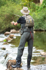 Naklejka premium Fisherman fishing on the River, holding Fishing Rod .