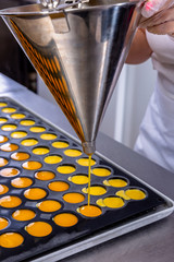 Pastry chef in the kitchen makes passion fruit confit. Cook pours passion fruit confit into the molds. Master class in the kitchen. The process of cooking. Step by step. Tutorial. Close-up