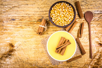 Dessert of curau. Brazilian sweet corn, corn mousse with cinnamon on a wooden background. Typical Brazilian dessert, sweet of June party. Dessert, canjica or Jimbelê.