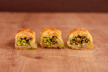 Turkish dessert baklava on wooden plate on row