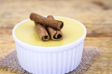 Brazilian sweet cream-like dessert cured corn mousse with cinnamon. Corn porridge with cinnamon in a bowl. Typical green corn foods tasty and cheap typical and popular street food