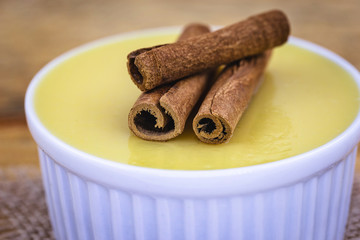 Dessert of curau. Brazilian sweet corn, corn mousse with cinnamon on a wooden background. Typical Brazilian dessert, sweet of June party. Dessert, canjica or Jimbelê.