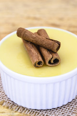Brazilian sweet cream-like dessert cured corn mousse with cinnamon. Corn porridge with cinnamon in a bowl. Typical green corn foods tasty and cheap typical and popular street food