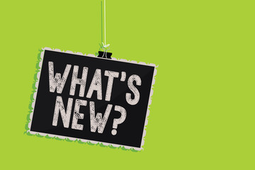 Conceptual hand writing showing What s is New question. Business photo text Asking about latest Updates Trends Happening News Hanging blackboard message communication sign green background