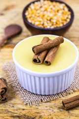Dessert of curau. Brazilian sweet corn, corn mousse with cinnamon on a wooden background. Typical Brazilian dessert, sweet of June party. Dessert, canjica or Jimbelê.