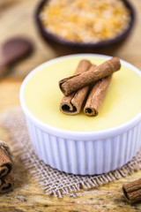 Dessert of curau. Brazilian sweet corn, corn mousse with cinnamon on a wooden background. Typical Brazilian dessert, sweet of June party. Dessert, canjica or Jimbelê.