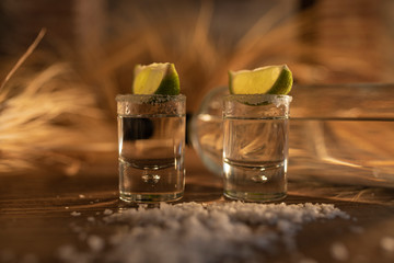 Two shot's of tequila with lemon slices and salt sprinkled by the table- Luxurious and delicious...