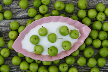 Fototapeta na wymiar sour green plums and besides salt, salt and green plums,