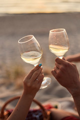 Couple clinking glasses of champagne at sunset
