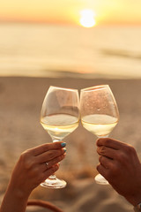 Couple clinking glasses of champagne at sunset