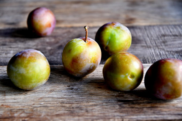 Plums in the garden in the morning, on old boards.