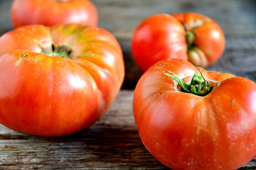 Ripe tomatoes directly from the garden in the morning on old boards.