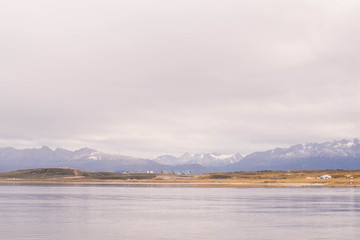 Minimalist landscape of a lake with mountains and a cloudy sky in Ushuaia, Argentina