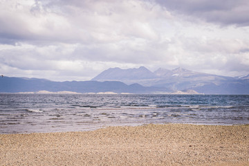 Playa de un lago con montañas detrás, en Ushuaia, Argentina
