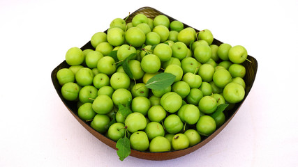 green plums, fresh plums, sour plums in a container, green and sour plums close-up,