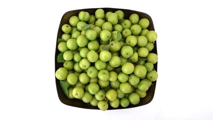 sour plums in a container, green and sour plums,