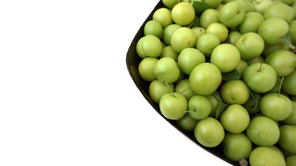 sour plums in a container, green and sour plums,