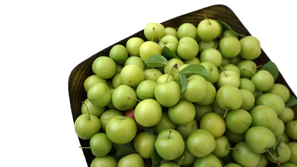 sour plums in a container, green and sour plums,
