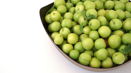 sour plums in a container, green and sour plums,