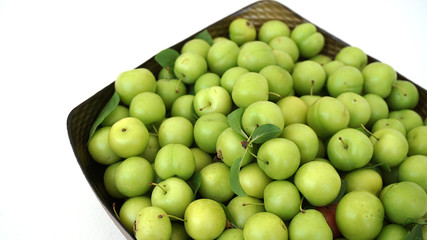 sour plums in a container, green and sour plums,