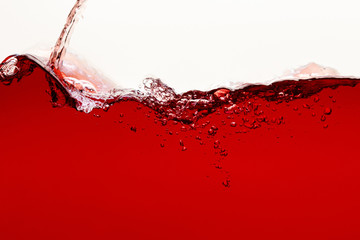 flowing red bright liquid with splash and bubbles isolated on white