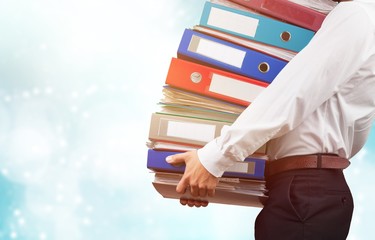 Young businessman with stack of papers