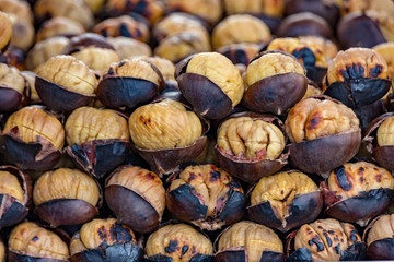 Vendor cart is stacked high with roasted chestnuts, sold as a quick snack in Istanbul