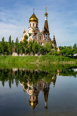 Christian church near Almaty, Kazakhstan reflected in lake