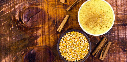 Dessert of curau. Brazilian sweet corn, corn mousse with cinnamon on a wooden background. Typical Brazilian dessert, sweet of June party. Dessert, canjica or Jimbelê.