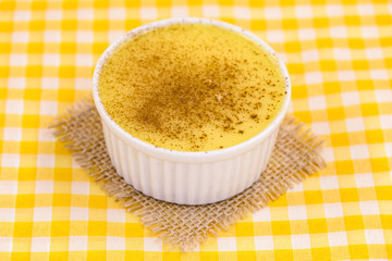 Brazilian sweet corn, corn mousse on a wooden background with copy space. Typical Brazilian dessert, sweet of mingua, called in Brazil of curau. Typical sweet of June party.