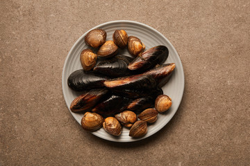 top view of plate with uncooked cockles and mussels on surface