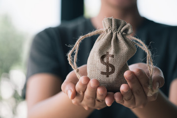 Women hand hold a money bag, a loan or saving money for future investment concept.