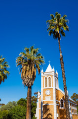 Small church at Bookpurnong with palm trees and blue sky background in rural South Australia