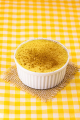 Dessert of curau. Brazilian sweet corn, corn mousse with cinnamon on a wooden background. Typical Brazilian dessert, sweet of June party. Dessert, canjica or Jimbelê.