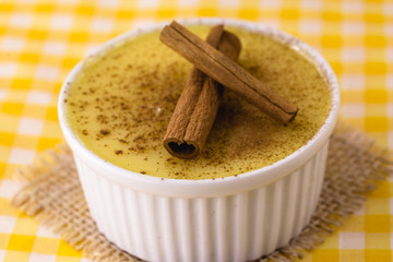 Dessert of curau. Brazilian sweet corn, corn mousse with cinnamon on a wooden background. Typical Brazilian dessert, sweet of June party. Dessert, canjica or Jimbelê.