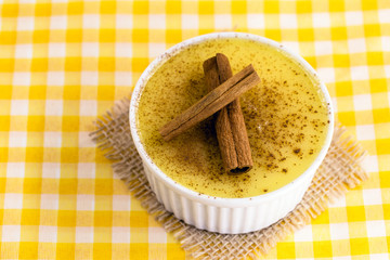 Brazilian sweet corn cream, Dessert, canjica or Jimbelê, dessert cured corn corn mousse with cinnamon on a wood background. Copy space