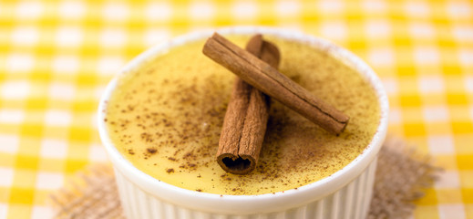 Dessert of curau. Brazilian sweet corn, corn mousse with cinnamon on a wooden background. Typical Brazilian dessert, sweet of June party. Dessert, canjica or Jimbelê.