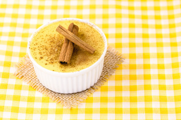 Dessert of curau. Brazilian sweet corn, corn mousse with cinnamon on a wooden background. Typical Brazilian dessert, sweet of June party. Dessert, canjica or Jimbelê.