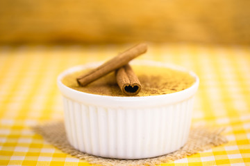 Dessert of curau. Brazilian sweet corn, corn mousse with cinnamon on a wooden background. Typical Brazilian dessert, sweet of June party. Dessert, canjica or Jimbelê.