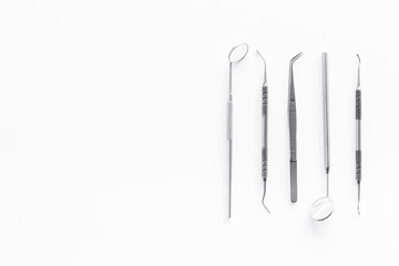 dentist instruments on white doctor's office desk background top view mock-up