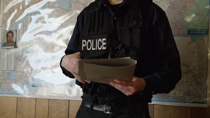 Police officer in precinct solving crimes