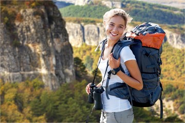 Fototapeta na wymiar Woman with backpack trekking through the wilderness
