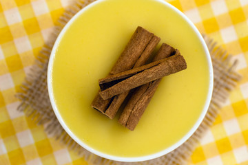 Dessert of curau. Brazilian sweet corn, corn mousse with cinnamon on a wooden background. Typical Brazilian dessert, sweet of June party. Dessert, canjica or Jimbelê.