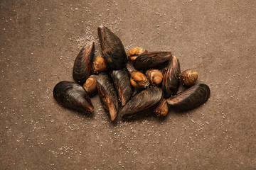 top view of raw cockles and mussels with sand on textured surface