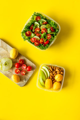meal in lunch box to take away on yellow background top view