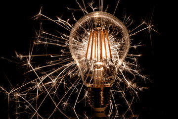 Fireworks sparkler behind LED light bulb burns