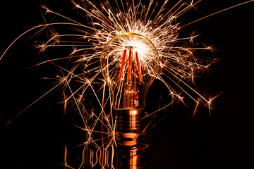 Fireworks sparkler behind LED light bulb burns
