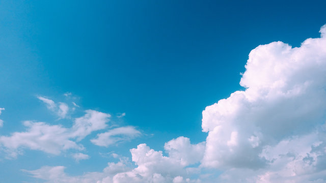 Beautiful bright blue sky with white fluffy clouds on a clear sunny day. Royalty high-quality free stock photo image of blue sky with white cloud, nice weather. Photo of natural cloudscape background