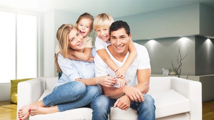 Young  family at home smiling at camera
